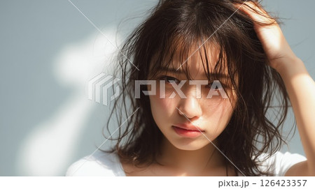 湿気でぼさぼさになった髪の毛で不機嫌になる女性 湿気でぼさぼさになった髪の毛で不機嫌になる女性 126423357