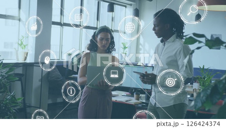 Image of icons over diverse business people using laptop in office 126424374