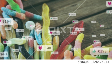 Colorful gummy worms with social media likes and comments image over them 126424953