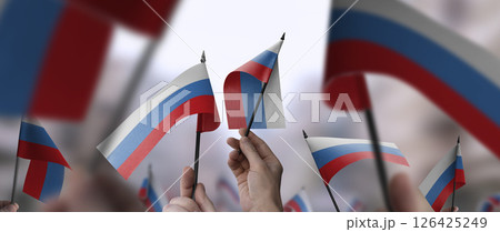 Russia flags in their hands on a blurred urban background Russia flags in their hands on a blurred urban background 126425249