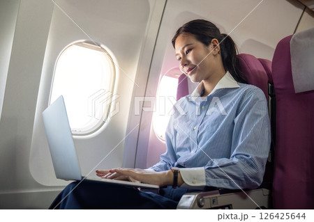Business travel productivity with passenger working on a laptop onboard 126425644