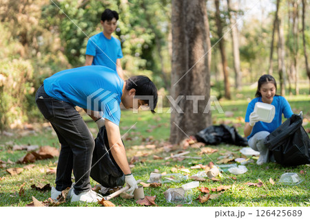 Dedicated volunteers. Young people focused on park cleanup tasks. 126425689
