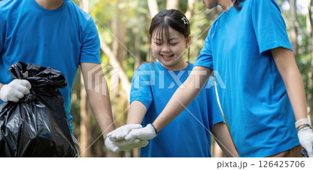 Family volunteers working together to collect garbage in a park, promoting environmental awareness and community service. Family volunteers working together to collect garbage in a park, promoting environmental awareness and community service. 126425706