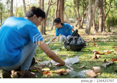 Sustainability and Volunteer Work. Two young volunteers cleaning up a park, demonstrating community engagement and environmental awareness. Sustainability and Volunteer Work. Two young volunteers cleaning up a park, demonstrating community engagement and environmental awareness. 126425707