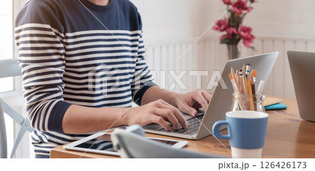 Close-up image of young professional male manager using laptop at he office, businessman working from home via portable computer Close-up image of young professional male manager using laptop at he office, businessman working from home via portable computer 126426173