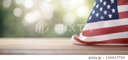 American flag draped on wooden table, symbolizing patriotism and freedom 126427784