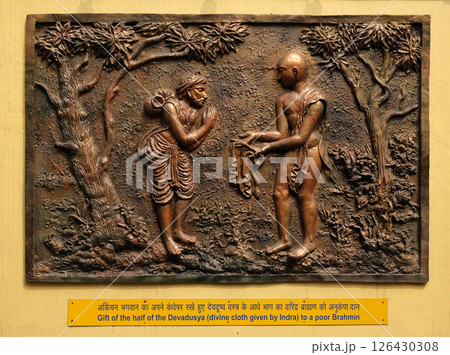 Gift of the half of the Devadusya (divine cloth given by Indra) to a poor Brahmin, Street bas relief on the wall of Jain Temple (also called Parshwanath Temple) in Kolkata, West Bengal, India Gift of the half of the Devadusya (divine cloth given by Indra) to a poor Brahmin, Street bas relief on the wall of Jain Temple (also called Parshwanath Temple) in Kolkata, West Bengal, India 126430308