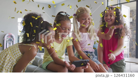 Image of gold confetti over happy diverse schoolgirls using smartphone and laughing in classroom Image of gold confetti over happy diverse schoolgirls using smartphone and laughing in classroom 126431160