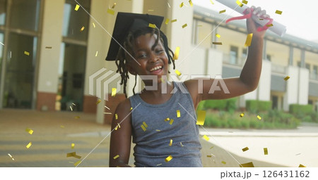 Image of gold confetti over happy african american schoolboy with diploma wearing mortarboard Image of gold confetti over happy african american schoolboy with diploma wearing mortarboard 126431162