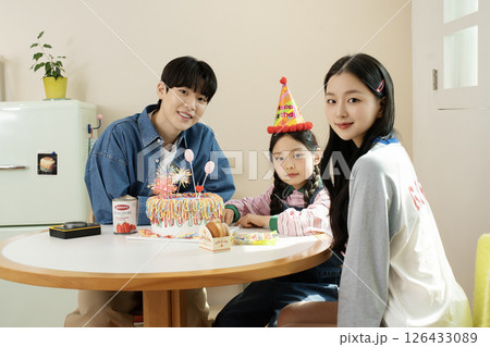 A family enjoying their daughter's birthday party at home 126433089