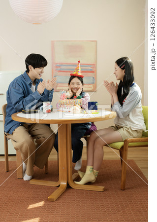 A family enjoying their daughter's birthday party at home 126433092