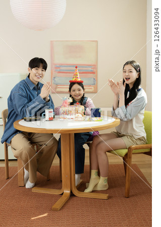 A family enjoying their daughter's birthday party at home 126433094