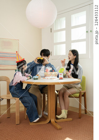 A family enjoying their daughter's birthday party at home A family enjoying their daughter's birthday party at home 126433112