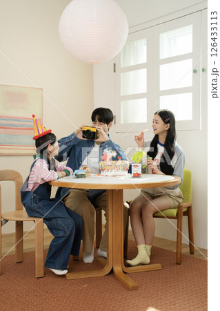 A family enjoying their daughter's birthday party at home 126433113