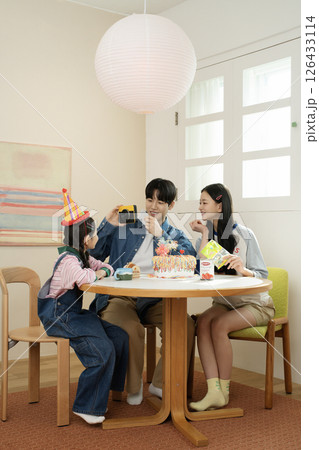 A family enjoying their daughter's birthday party at home 126433114