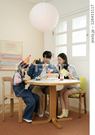 A family enjoying their daughter's birthday party at home 126433117