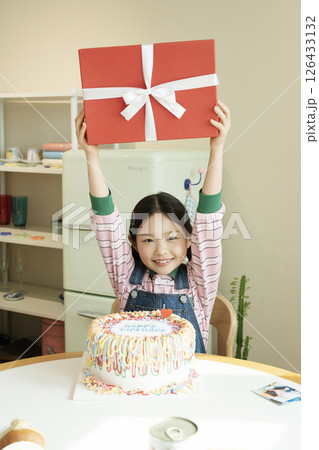 A cute little girl happy to receive a birthday present 126433132