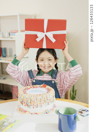 A cute little girl happy to receive a birthday present 126433133