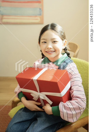 A cute little girl happy to receive a birthday present 126433136