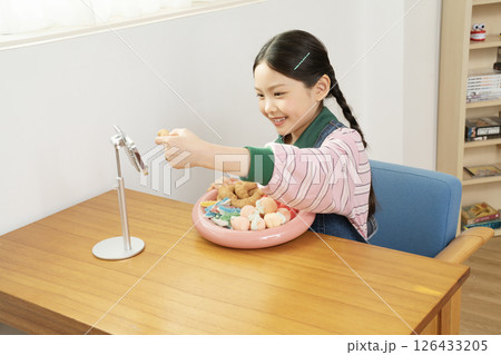 A cute child YouTuber who stands up on his smartphone and films a mukbang 126433205