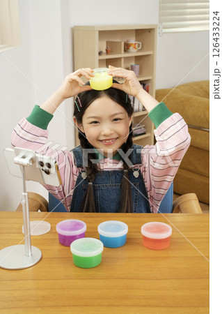 A cute child YouTuber who puts his smartphone upright and takes pictures while playing with slime. 126433224