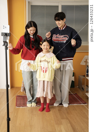 The MZ family filming a short-form challenge with a mobile phone tripod set up. The MZ family filming a short-form challenge with a mobile phone tripod set up. 126433231