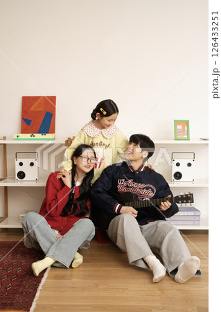 MZ family holding a guitar and filming a short form challenge 126433251