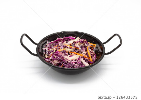 Top view of coleslaw with shredded purple cabbage carrot and white cabbage served in black handled bowl on white background 126433375