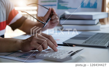 Businessman pen pointing graph chart in this mounth and use calculator for Plans to improve quality next month. 126434427