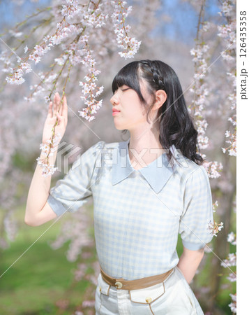 桜の花の香りをかぐ若い女性 126435358