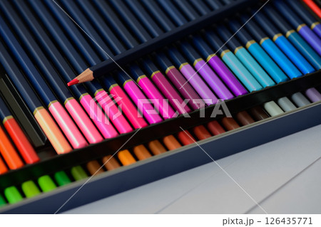 Two rows of colored pencils with a sharp point on red pencil in pencil case Two rows of colored pencils with a sharp point on red pencil in pencil case 126435771
