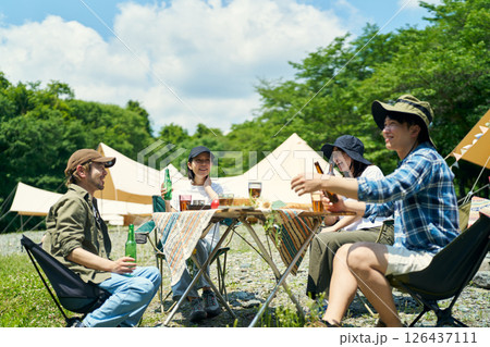 キャンプ場でバーベキューを楽しむ男女 キャンプ場でバーベキューを楽しむ男女 126437111