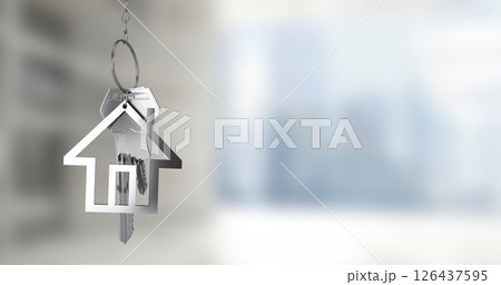 House-shaped keychain with keys over blurred cityscape image 126437595