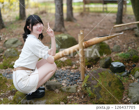 鹿おどしでワンポイントをする女性 鹿おどしでワンポイントをする女性 126437705