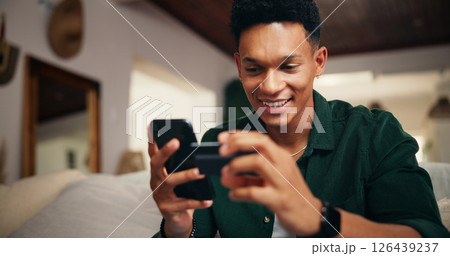 Credit card, phone and relax with man on sofa for online shopping, digital payment or fintech. Internet banking, account password and customer purchase with person in living room of home for order 126439237