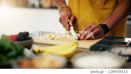 Cooking, hands and cut banana in kitchen for meal preparation, healthy salad and lunch recipe. Nutrition, closeup and person with fresh fruit ingredients in home for vegetarian snack and organic diet Cooking, hands and cut banana in kitchen for meal preparation, healthy salad and lunch recipe. Nutrition, closeup and person with fresh fruit ingredients in home for vegetarian snack and organic diet 126439323