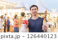 An Asian young man travels with street food. 126440123
