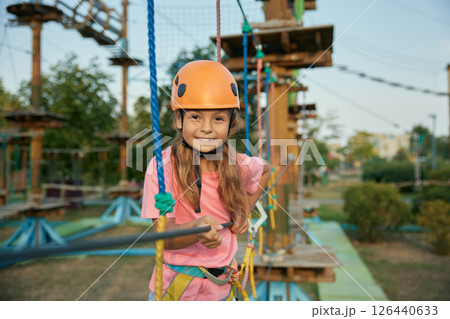 Young girl accuracy walking rope track enjoying extreme entertainment Young girl accuracy walking rope track enjoying extreme entertainment 126440633