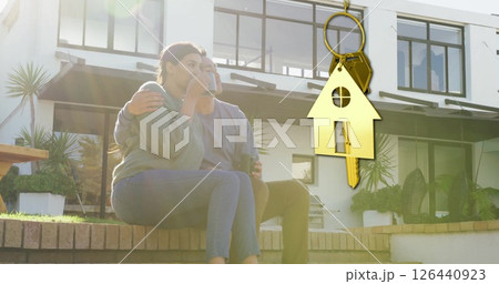 Image of gold house key and key fob over happy biracial couple by house 126440923