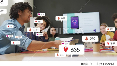 Image of media icons over diverse colleagues discussing work Image of media icons over diverse colleagues discussing work 126440948
