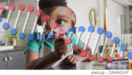 Image of dna strand over african american boy with magnifying glass in laboratory 126442247