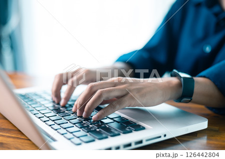 Woman sits at table, using her mobile phone to navigate social media and conduct business through latest technology in cyberspace. social media, table, mobile phone, technology, person, cyberspace. 126442804