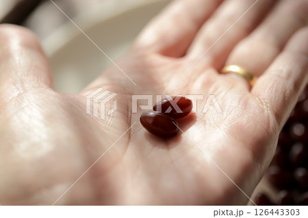 プラセンタサプリメントを2粒を乗せた50歳代女性の手 プラセンタサプリメントを2粒を乗せた50歳代女性の手 126443303