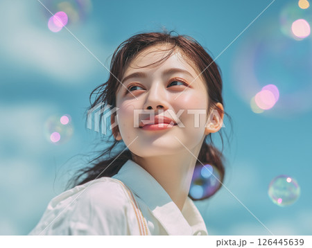 明るく爽やかな表情の20代アジア人女性のポートレート（希望・春の空） 126445639