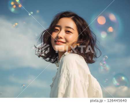 明るく爽やかな表情の20代アジア人女性のポートレート（希望・春の空） 126445640