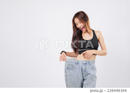 Weight change made her pants loose and her smile brighter. Her new shape proves that managing weight can lead to big happiness. isolated studio white background Weight change made her pants loose and her smile brighter. Her new shape proves that managing weight can lead to big happiness. isolated studio white background 126446164