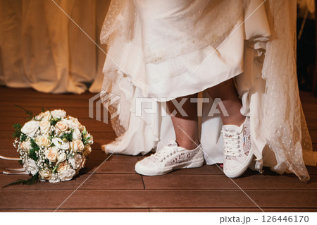 Bride Wearing Sneakers and Standing Next to Bouquet 126446170