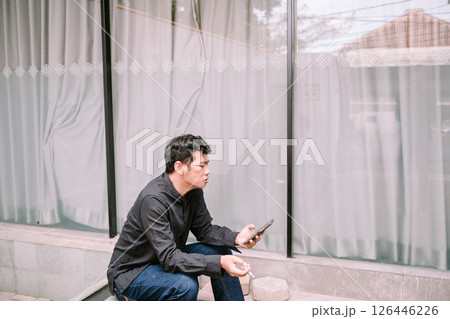 Thoughtful man smoking, contemplative pose in neutral environment 126446226