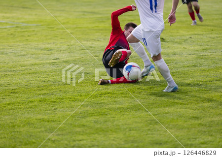 Football players at the stadium with the ball score a goal to the goalkeeper 126446829