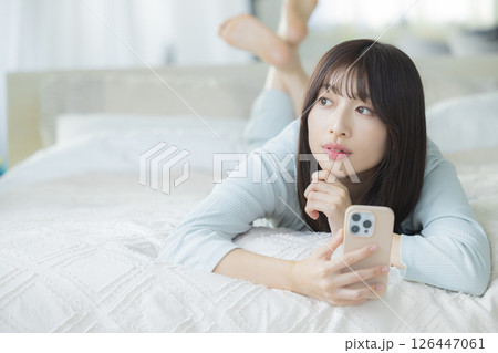 ベッドでスマホを見る女性 ベッドでスマホを見る女性 126447061